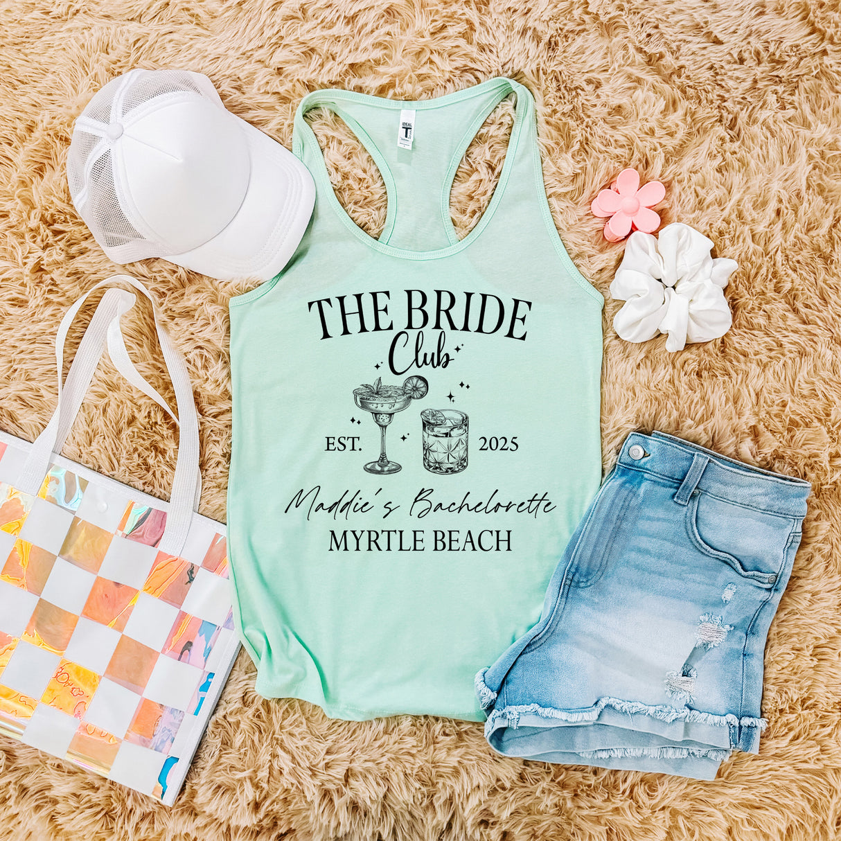 Personalized bachelorette shirts flat lay, featuring custom bride tribe tank tops, bridesmaid shirts, and matching bridal party outfits for bachelorette weekends.