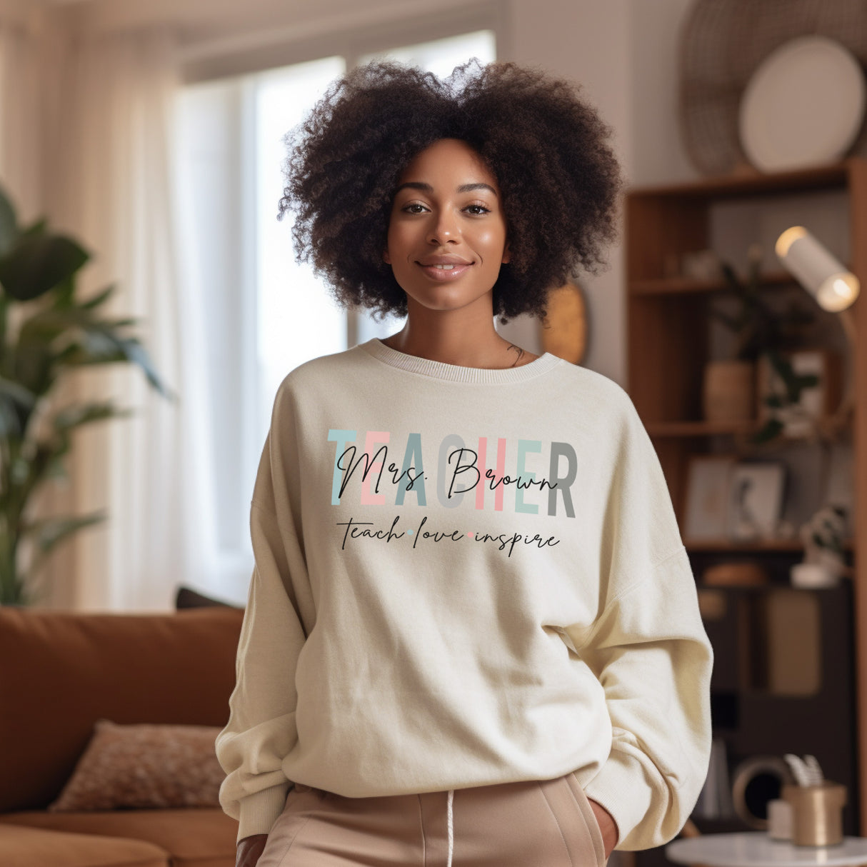 The perfect gift for teachers this upcoming teacher appreciation week. Women wearing sand sweatshirt with teacher design, and her custom last name.