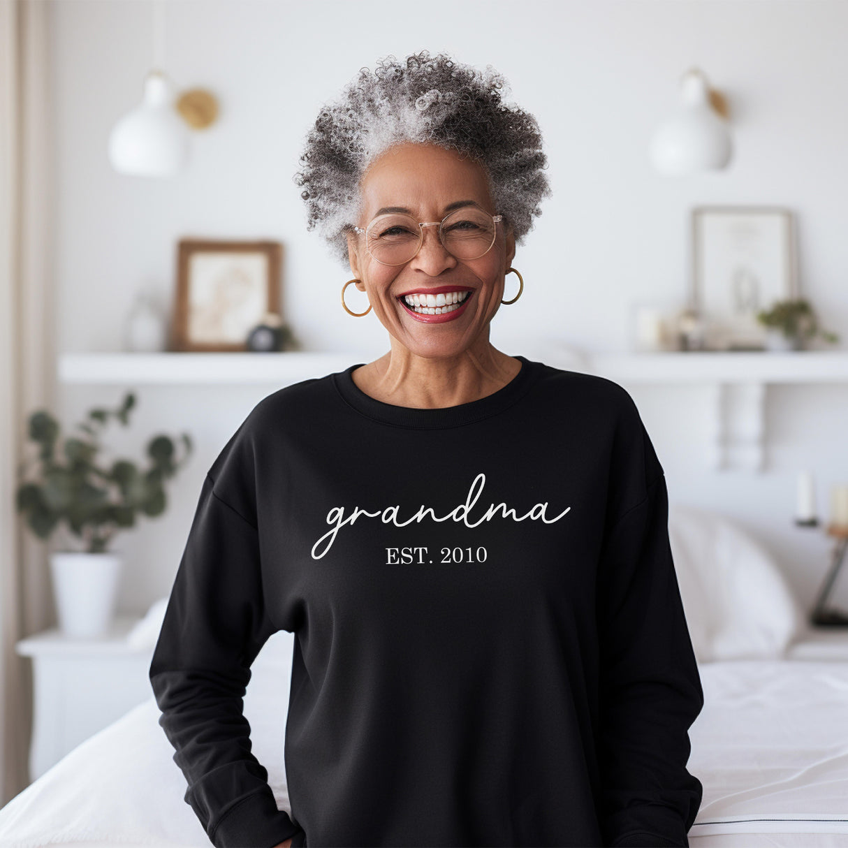 Grandma wearing adorable sweatshirt with the custom year she became a grandma.