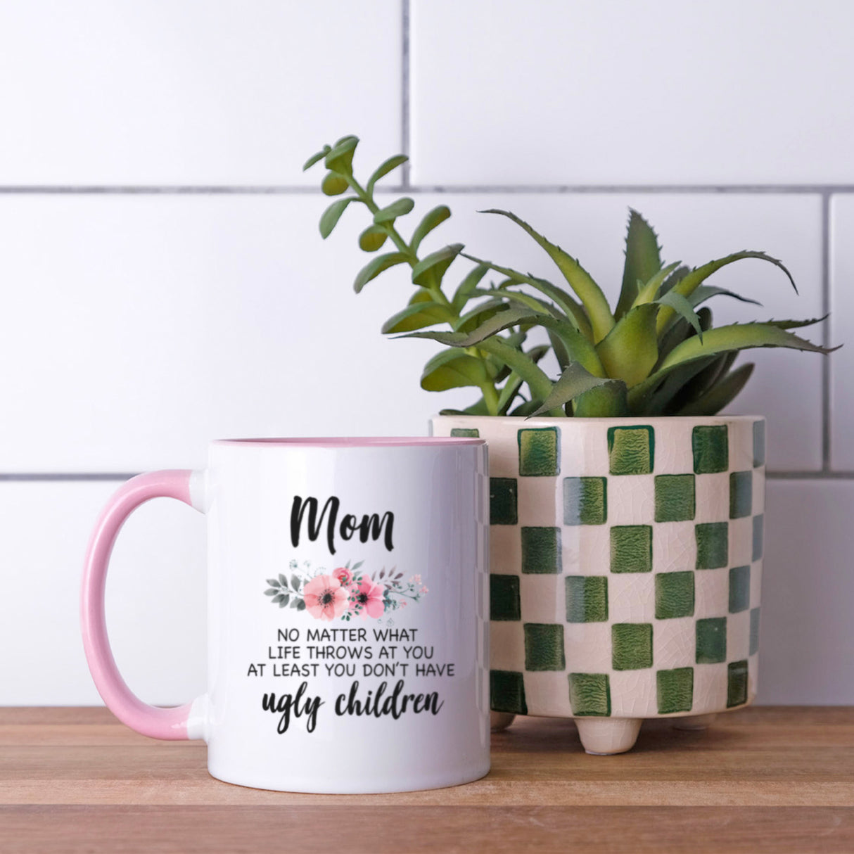 Pink humorous coffee mug for mom featuring Mom, no matter what life throws at you, at least you don’t have ugly children, text and a beautiful floral design, ideal for birthday or Christmas.