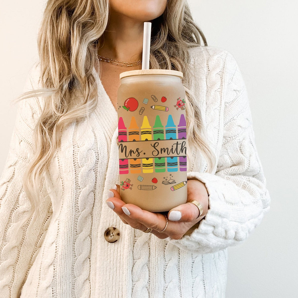 Woman with personalized teacher cup, crayon-themed frosted glass tumbler for Teacher Appreciation Week.