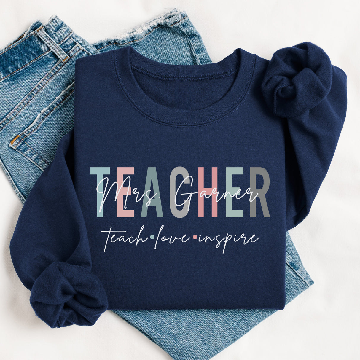 Custom teacher crewneck sweatshirt in flat lay, personalized with last name and inspirational quote for teacher gifts.