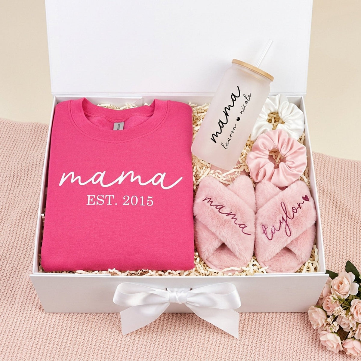 Bundle gift set for mom with mama sweatshirt, fluffy slippers, glass can and scrunchies. The set is packaged ready for gifting in a cute white box with bow and message.