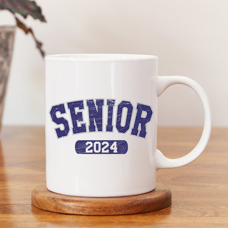 Senior 2024 graduation coffee mug sitting on a desk. This gift is the perfect graduation gift for him or her. All SKUs. 