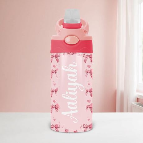 Coquette bow personalized water bottle for kids with custom name and flip top lid, ideal for school or toddlers.