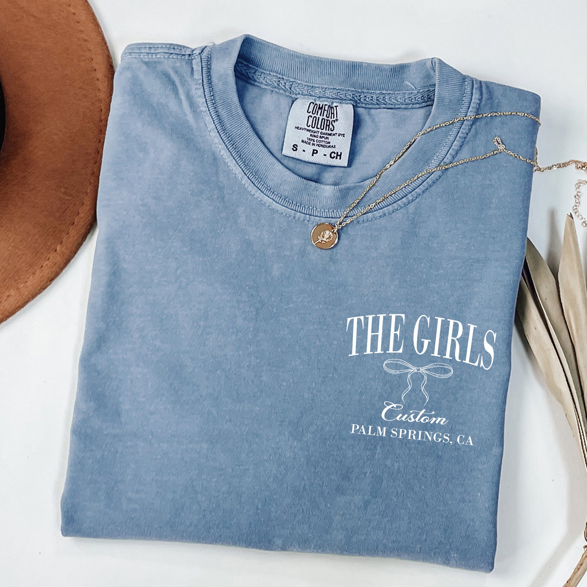 Blue custom bachelorette shirt featuring a coquette bow design, personalized with names and date for bride-to-be and bridesmaids. Gifts for bride or bridesmaid.