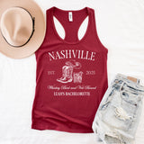 Flat lay of personalized Nashville bachelorette tank tops with custom bride and bridesmaid names, perfect for country themed bridal parties. 