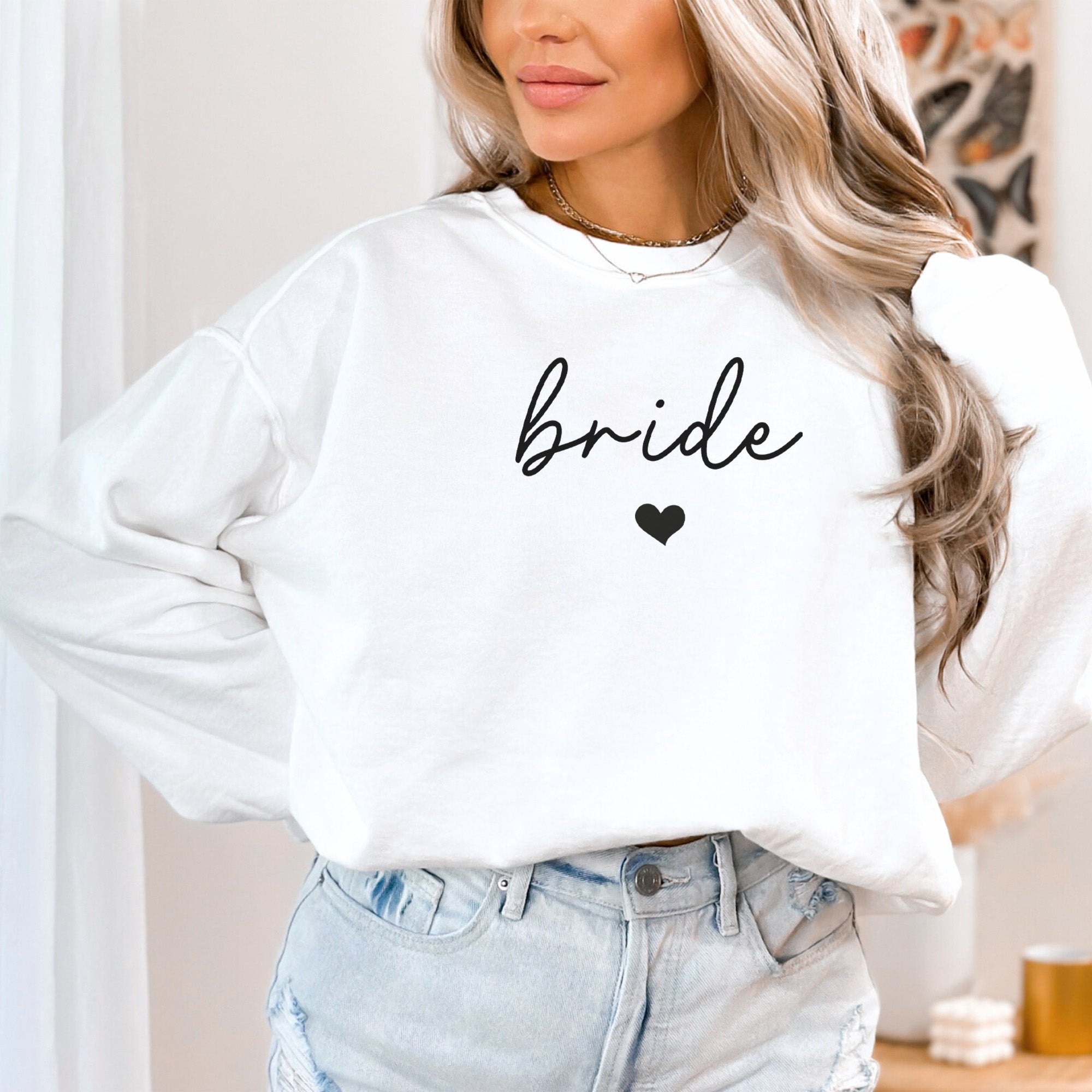 Woman lounging in an oversized Comfort Colors bride sweatshirt, styled for a cozy bachelorette party shirt or wedding morning photos. 