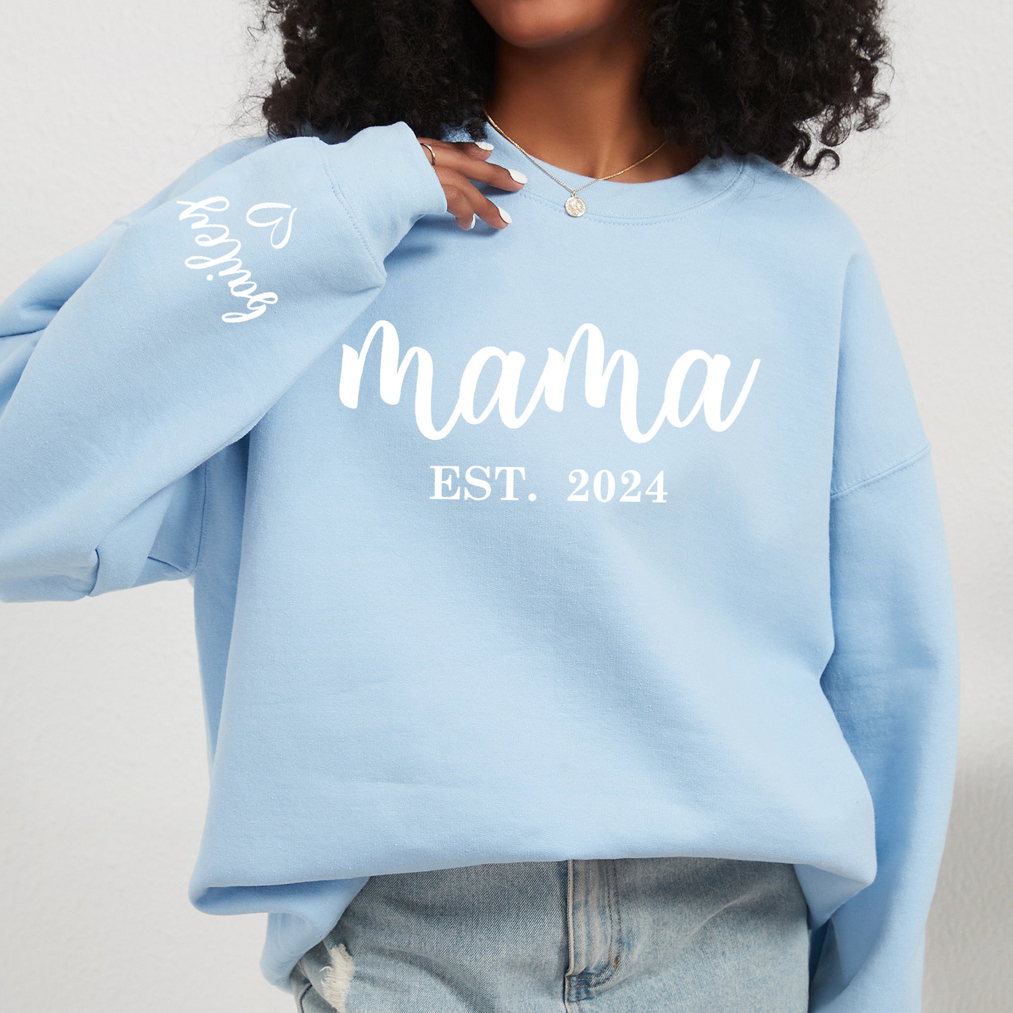 Mother celebrating Mother's Day in a custom sweatshirt that reads Mama. Mothers day with year custom on sweatshirt for gift ideas.  