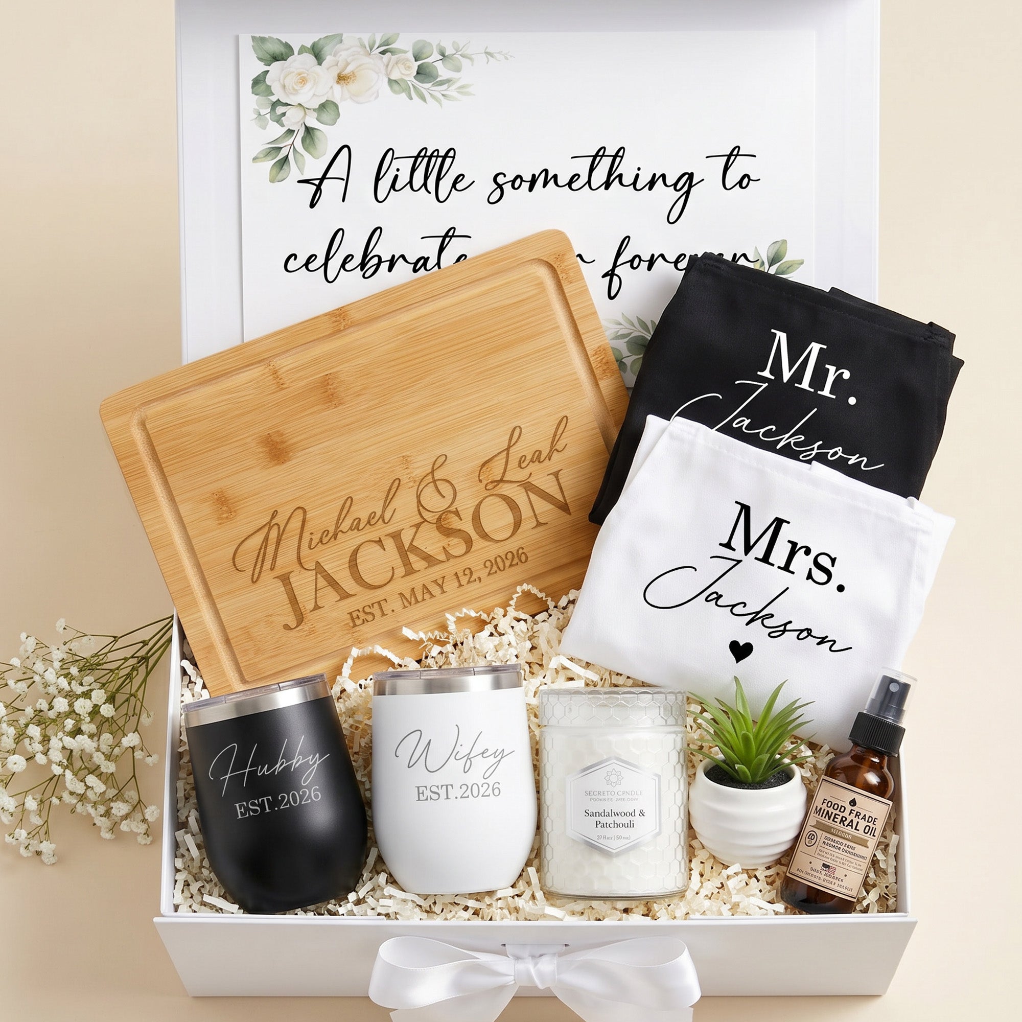 Gift set with personalized items including a cutting board, tumblers, and aprons in a magnetic gift box. Food grade protecting oil, scented candle and plant is also included.