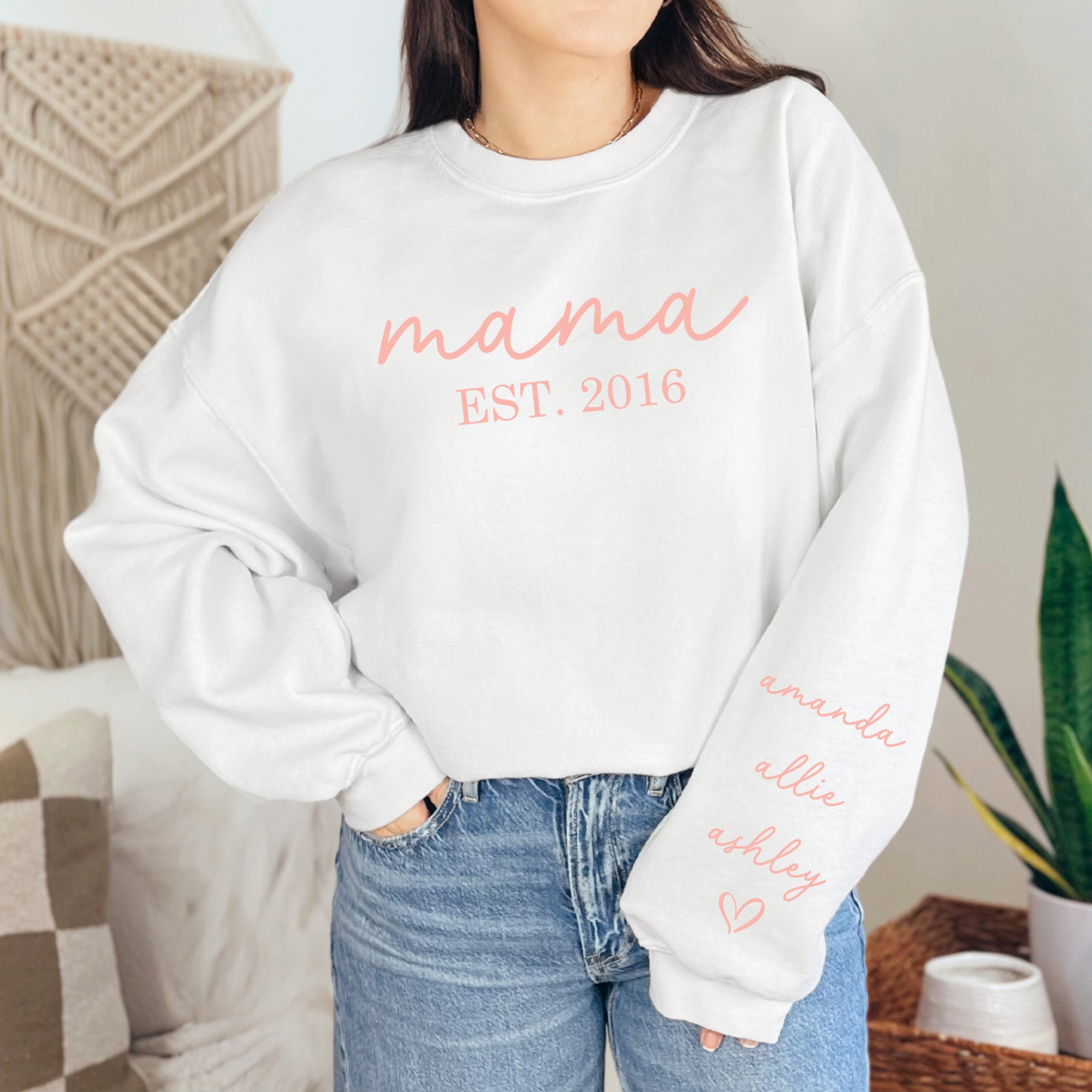 White and pink customizable sweatshirt for moms featuring kids' names and year of motherhood, ideal birthday gift. 