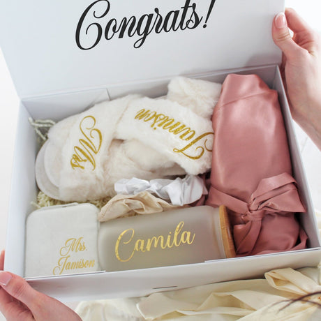 Custom bridesmaid gift set featuring a robe with name, slippers, Libbey can glass, and scrunchies for bridal party proposals. 