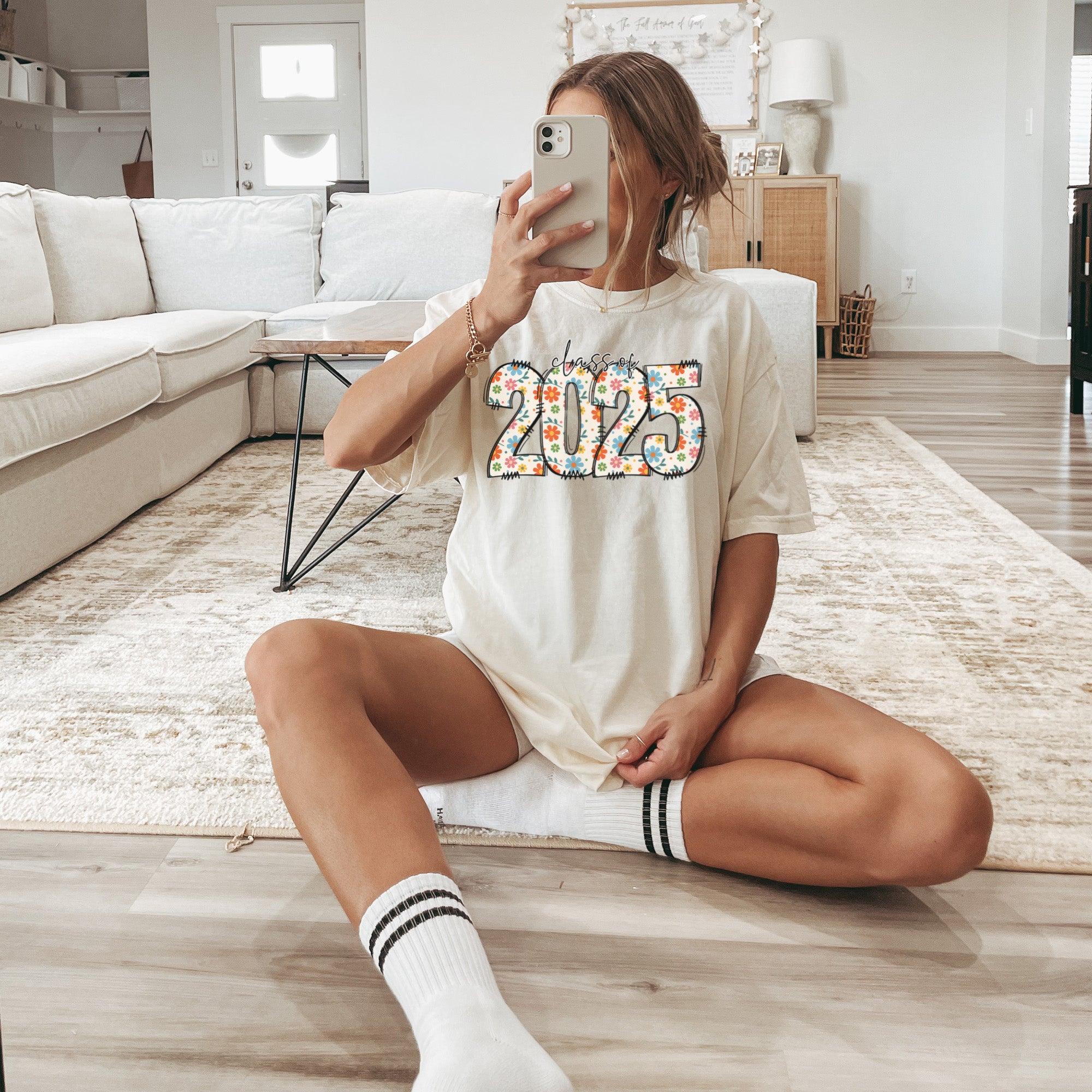 Soft cotton graduation shirt with colorful flower accents and bold 2025 print. Teen girl celebrating graduation in soft Comfort Colors tee.