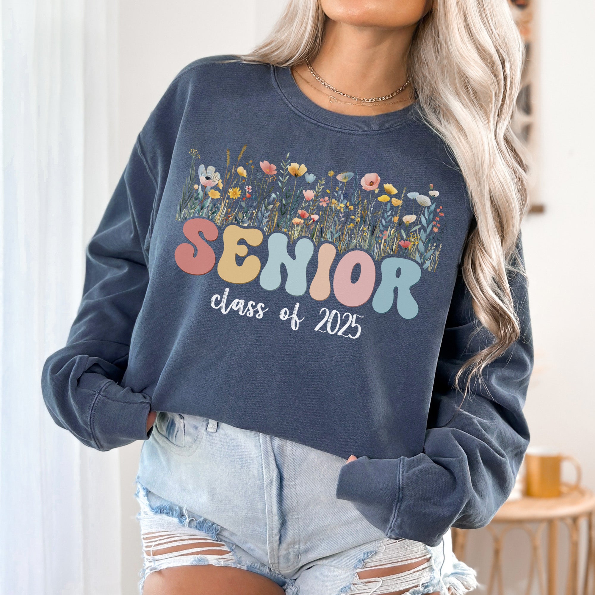 Senior of 2025 wearing a floral comfort colors sweatshirt with flowers. Cute graduation sweatshirts for the class of 2025.