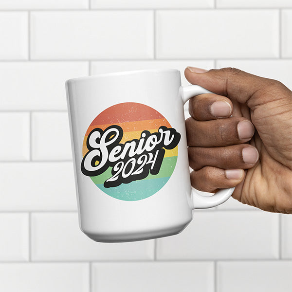 Man holding a Senior 2024 graduation coffee mug. The perfect graduation gift idea. All SKUs. 