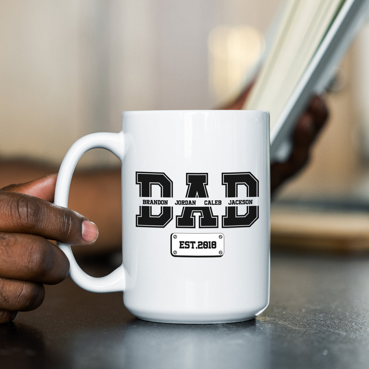 Father drinking from personalized coffee mug with kids names, perfect gift idea for him on Father’s Day, birthday, or new dad celebration.