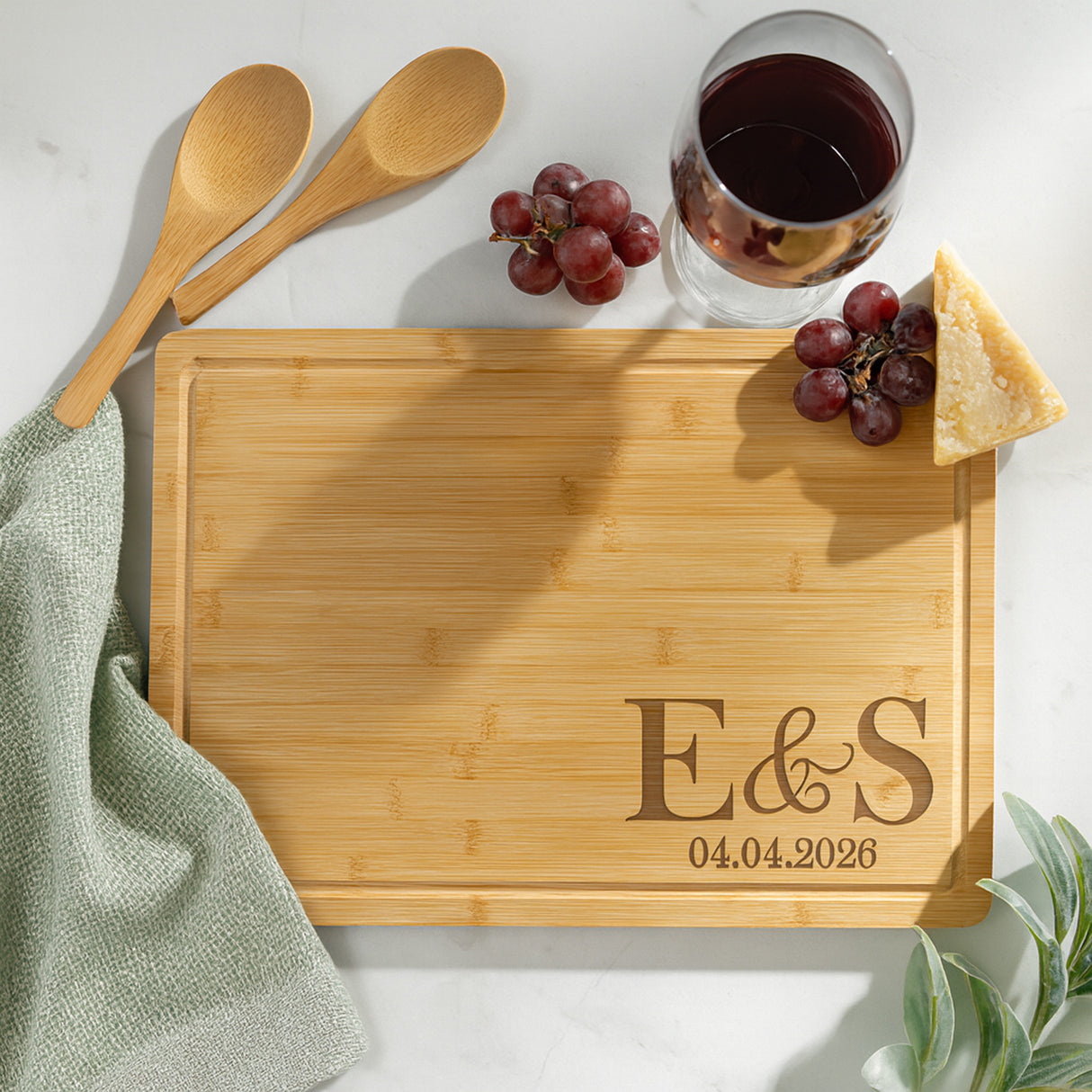Bamboo wood cutting board personalized with initials for couple and wedding gifts.