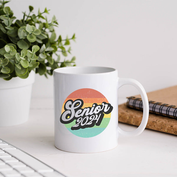 Senior graduation coffee mug gift sitting on a desk. Ideal coffee mug for high school and college graduates. All SKUs. 