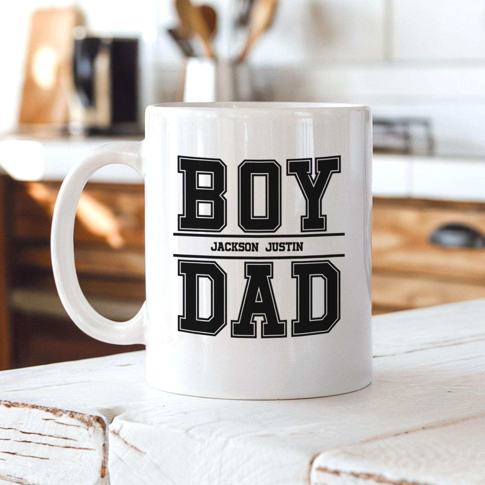 Personalized coffee mug for boy dad with kids names, custom Father’s Day gift, white ceramic mug displayed on kitchen counter.