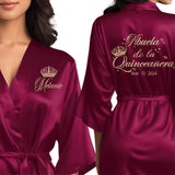 Front and back personalized satin quinceanera robes at knee length. Abuela de la quinceanera getting ready robes.