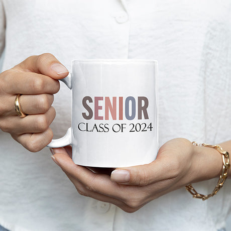 Woman holding senior class of 2024 coffee mug to commemorate the class of 2024. All SKUs.