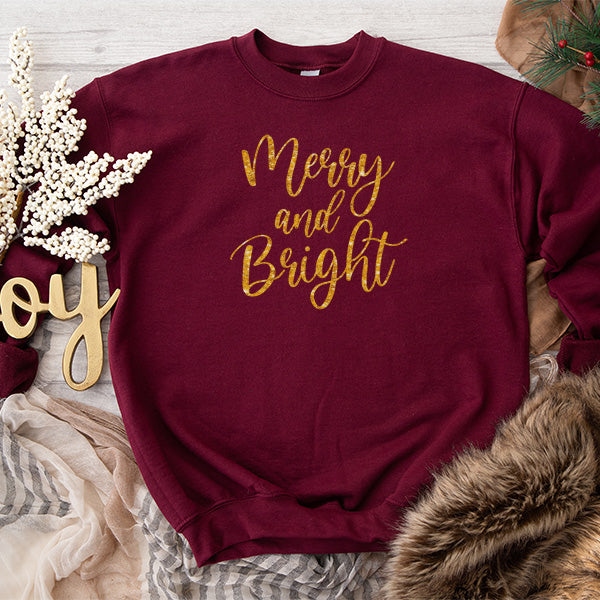 Merry and Bright Gold Glitter Lettering on Maroon Sweatshirt.  Flat lay photo. Holiday sweatshirt for men, women and children.  all SKUs