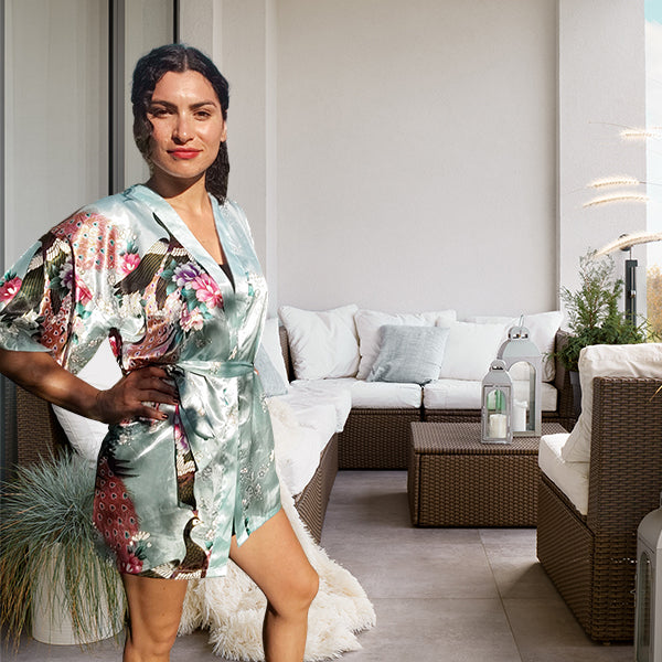 model wearing short floral sky blue robe sideview balcony